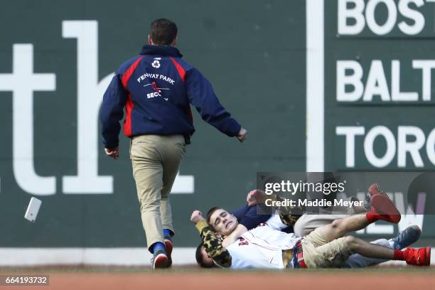 Fan is tackled by security after rushing the field during the eighth inning of the opening day game between the Boston Red Sox and the Pittsburgh...