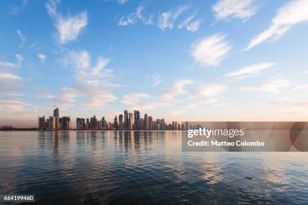 qatar, doha. skyline at sunrise from the corniche - corniche stock pictures, royalty-free photos & images