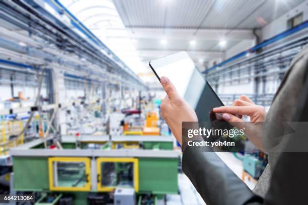 nahaufnahme von digital-tablette & futuristischen fabrik - shaping future stock-fotos und bilder