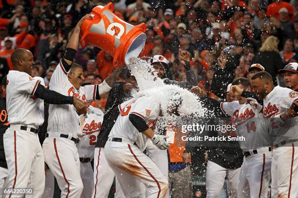 Mark Trumbo of the Baltimore Orioles is greeted at home plate after hitting a walk-off home run against the Toronto Blue Jays during the eleventh...