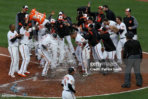 Mark Trumbo of the Baltimore Orioles is greeted at home plate after hitting a walk-off home run against the Toronto Blue Jays during the eleventh...