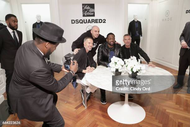 Designers Dean Caten and Dan Caten and basketball player Dwyane Wade pose with fans during Saks Fifth Avenue Celebrates the Exclusive Launch of The...