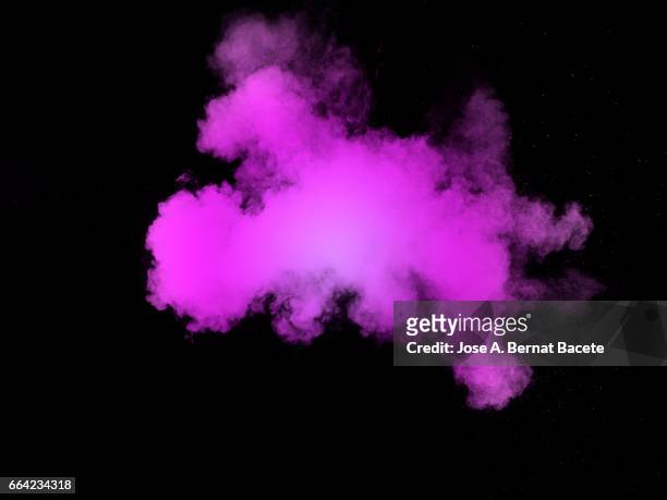 explosion of a cloud of powder of particles of  colors  pink on a black background - partícula stock-fotos und bilder