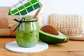 Homemade avocado beauty mask in a glass jar. Prepared from avocado puree and olive oil. DIY cosmetics.