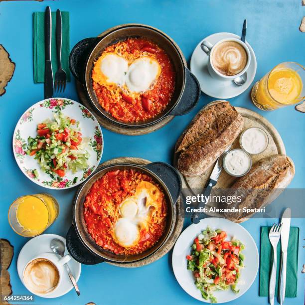 traditional israeli breakfast with shakshuka and hummus, tel aviv, israel - square plate stock-fotos und bilder