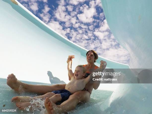 mutter und sohn spaß auf einer wasserrutsche - wasserrutsche stock-fotos und bilder