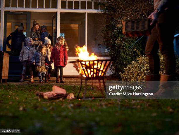 young family preparing to go outside on cold winters night - bonfire night uk stock-fotos und bilder