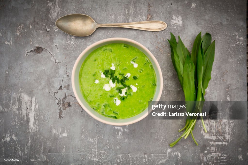 Bowl of bears garlic soup and fresh ramson leaves