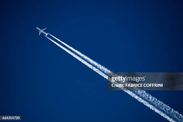 Commercial plane of German airline Lufthansa leaves a contrail on the sky on April 3, 2017 above the Swiss Alps resort of Verbier.