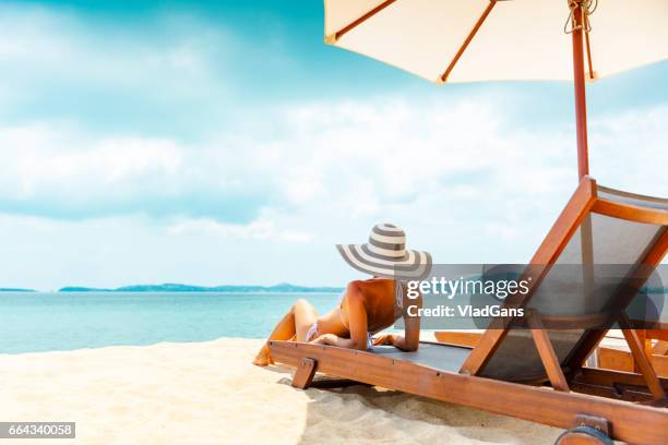 woman in beach chair - sun lounger stock pictures, royalty-free photos & images