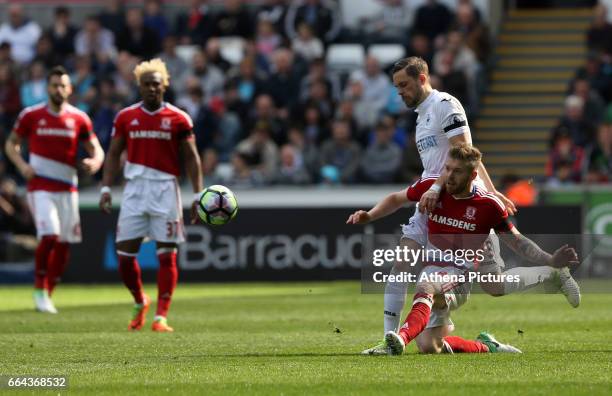 Gylfi Sigurdsson of Swansea City is challenged by Adam Clayton of Middlesbrough during the Premier League match between Swansea City and...