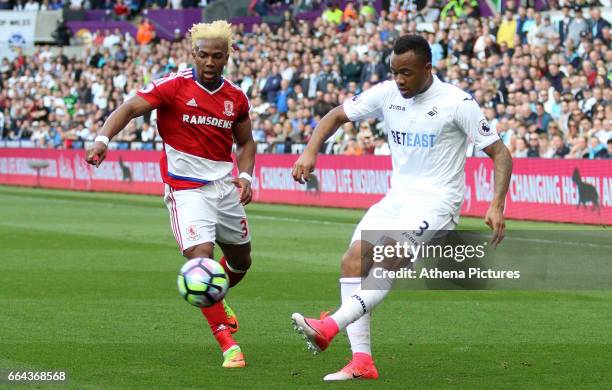 Jordan Ayew of Swansea City is challenged by Adama Traoré of Middlesbrough during the Premier League match between Swansea City and Middlesbrough at...