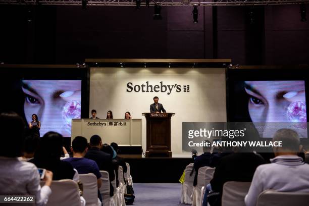 David Bennett , head of Sotheby's International Jewellery Division, prepares to auction a 59.60-carat giant diamond named the "Pink Star", resulting...