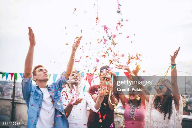 alegre amigos con confeti en la fiesta en la azotea - pendón fotografías e imágenes de stock