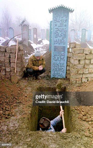 Chechen man digs a grave for a relative in Argun, a town some 20 kms. Away from the Chechn capital Grozny after tens of civilians were killed during...
