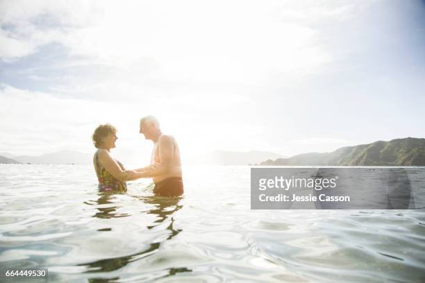 Older couple in sea at sunset