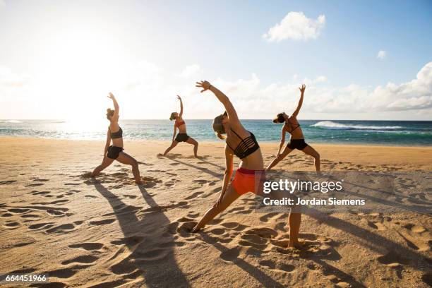 friends doing yoga in the sand. - woman stretching sunset bildbanksfoton och bilder