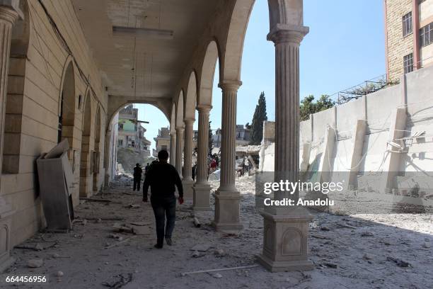 People inspect the area after Russian warcrafts allegedly carried out airstrikes at Ravda Mosque and market in Salkin town of Idlib, Syria on April...