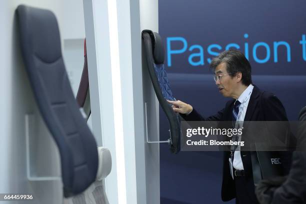 An attendee inspects a 'Delta' airline seat cover displayed at the Sabeti Wain pavilion at the 2017 Aircraft Interiors Expo in Hamburg, Germany, on...