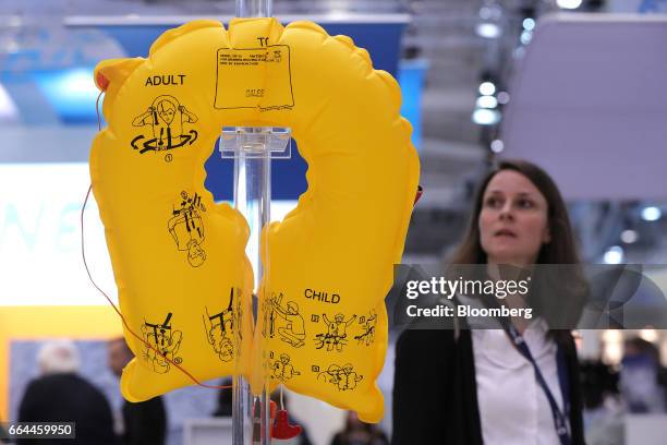 An attendee looks at an emergency life vest manufactured by EAM Worldwide at the Aircraft Interiors Expo in Hamburg, Germany, on Tuesday, April 4,...