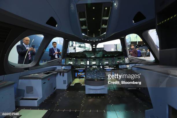 Attendees look at an aircraft cockpit section with an interior manufactured by Hutchinson Composite Industrie at the 2017 Aircraft Interiors Expo in...