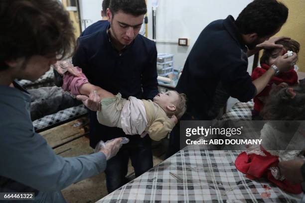 Syrian children receive treatment at a makeshift clinic following reported air strikes by government forces in the rebel-held town of Douma, on the...