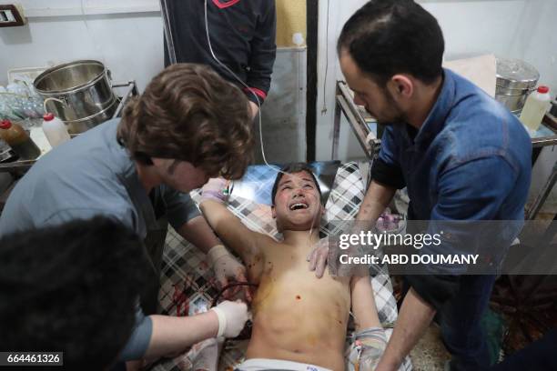 Graphic content / A Syrian boy receives treatment at a makeshift clinic following reported air strikes by government forces in the rebel-held town of...