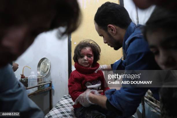 Syrian girl receives treatment at a makeshift clinic following reported air strikes by government forces in the rebel-held town of Douma, on the...