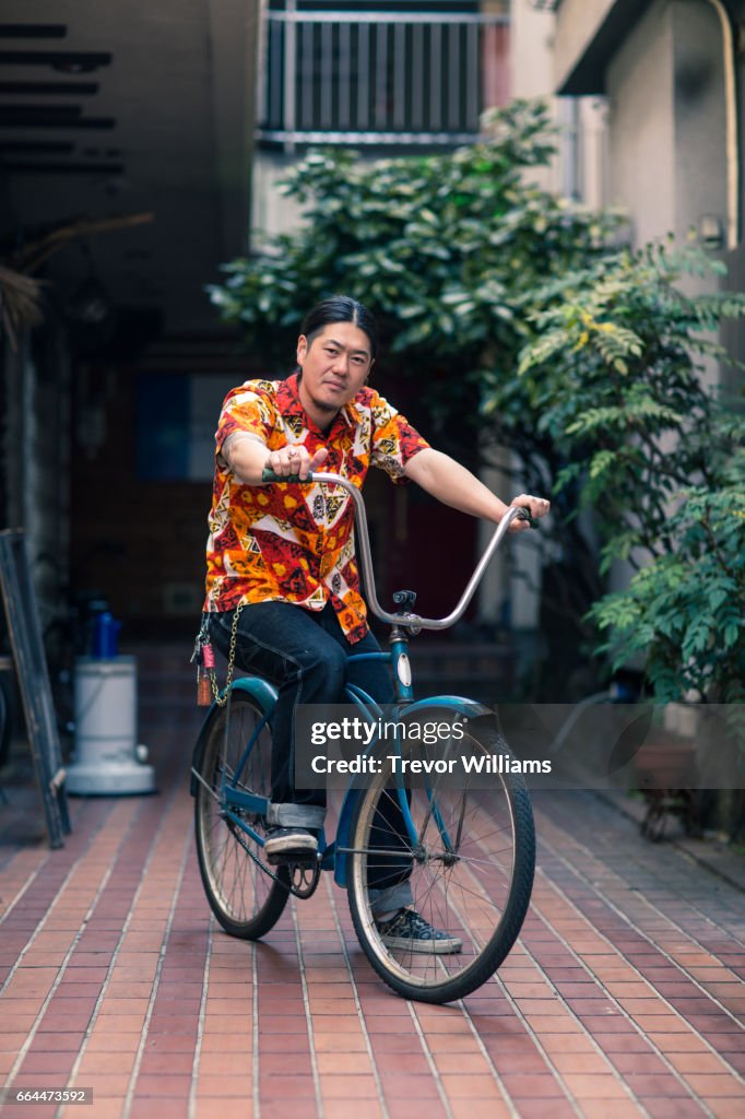 Mid adult man posing on a retro styled vintage bicycle