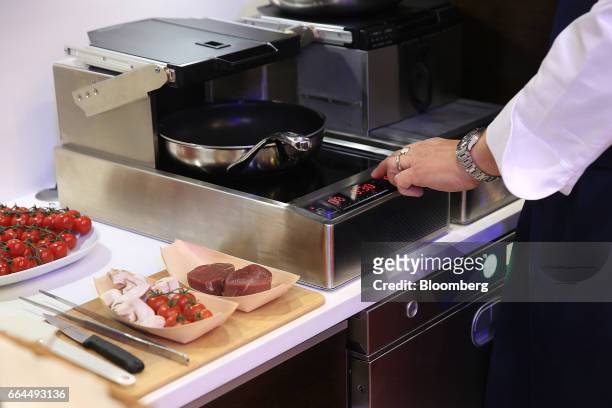 An attendee demonstrates the operation of a flight safe cooking system by Lufthansa Technik AG at the Aircraft Interiors Expo in Hamburg, Germany, on...