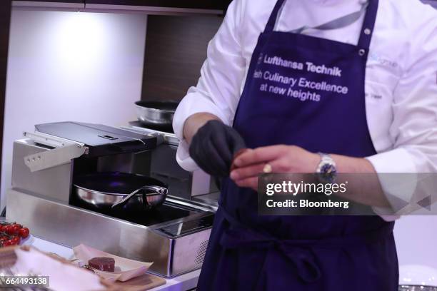 An attendee demonstrates the operation of a flight safe cooking system by Lufthansa Technik AG at the Aircraft Interiors Expo in Hamburg, Germany, on...