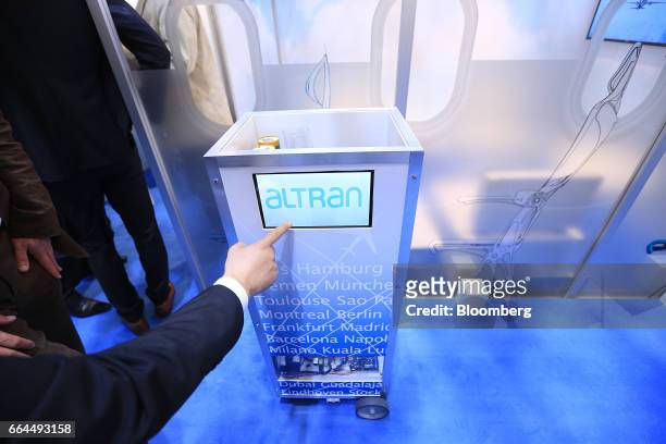 Attendees inspect a robotic waiter catering device manufactured by Altran Technologies SA at the Aircraft Interiors Expo in Hamburg, Germany, on...