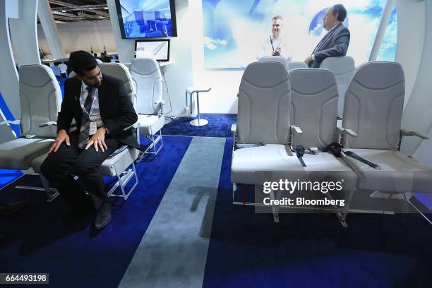 An attendee tests a Molon Labe Designs side-slip passenger seat at the Aircraft Interiors Expo in Hamburg, Germany, on Tuesday, April 4, 2017....