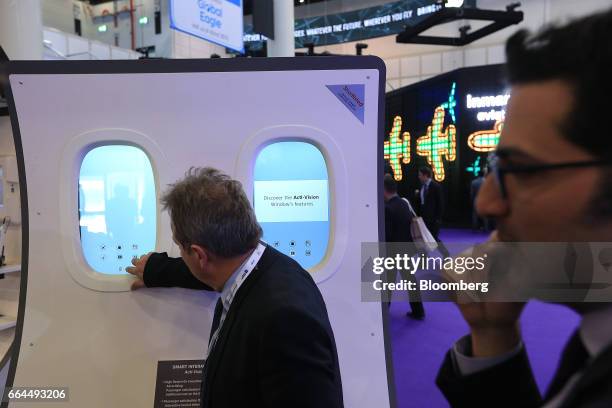 An attendee tests a smart interactive window technology manufactured by Acti-Vision at the Aircraft Interiors Expo in Hamburg, Germany, on Tuesday,...
