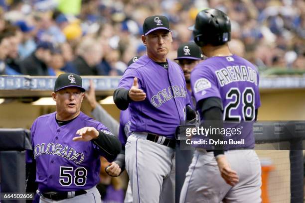 Hitting coach Duane Espy and manager Bud Black of the Colorado Rockies congratulate Nolan Arenado after scoring a run in the fourth inning against...