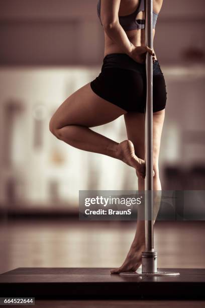 unrecognizable pole dancer's body leaning on a pole. - pole dance stock pictures, royalty-free photos & images