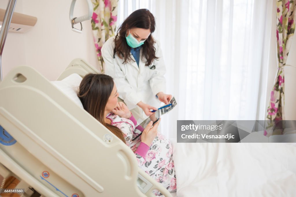 Doctor's Talking To Pregnant Woman At Hospital