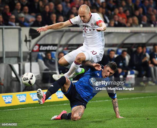 Steven Zuber of 1899 Hoffenheim tackles Arjen Robben of Bayern Munich during the Bundesliga match between TSG 1899 Hoffenheim and Bayern Muenchen at...