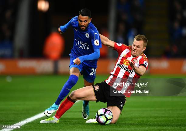 Riyad Mahrez of Leicester City attempts to escape a challenge from Sebastian Larsson of Sunderland during the Premier League match between Leicester...