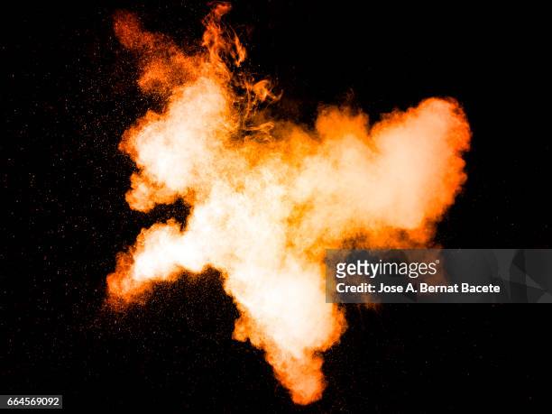explosion of a cloud of powder of particles of  colors yellow and orange on a black background - etéreo stock pictures, royalty-free photos & images