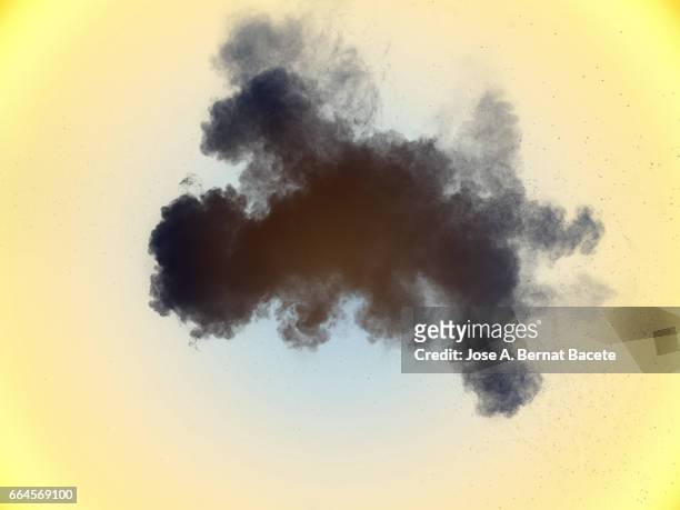 explosion of a cloud of powder of particles of  color gray on a yellow background - explotar photos et images de collection