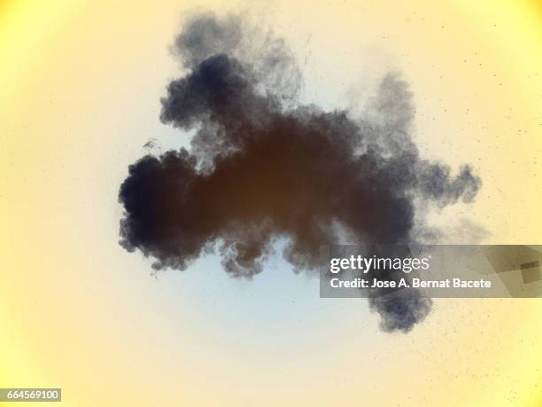 explosion of a cloud of powder of particles of  color gray on a yellow background - etéreo stockfoto's en -beelden