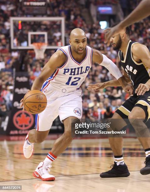 Gerald Henderson of the Philadelphia 76ers dribbles as Cory Joseph of the Toronto Raptors guards him during NBA game action at Air Canada Centre on...