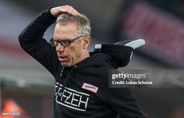 Head Coach Peter Stoeger of Koeln lost his cap during the Bundesliga match between 1. FC Koeln and Eintracht Frankfurt at RheinEnergieStadion on...