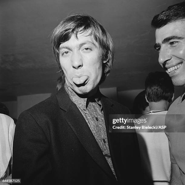 Rolling Stones drummer Charlie Watts sticking out his tongue, Television House, London, 26th June 1964. Watts and the rest of the the group are at...