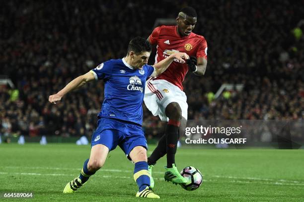 Everton's English midfielder Gareth Barry vies with Manchester United's French midfielder Paul Pogba during the English Premier League football match...