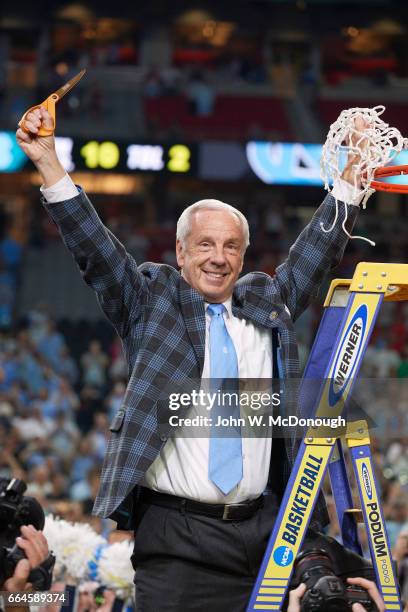 Finals: North Carolina coach Roy Williams victorious on ladder after cutting net after winning game vs Gonzaga at University of Phoenix Stadium....