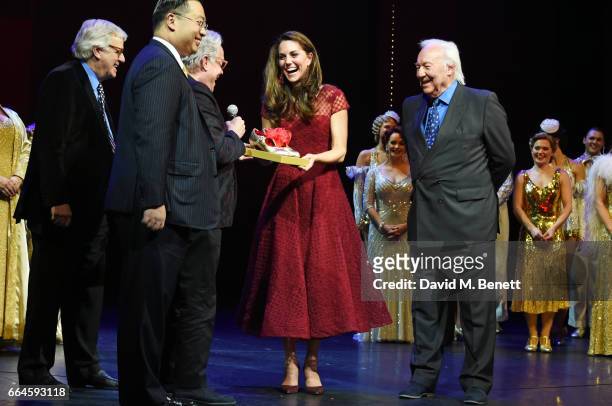 Catherine, Duchess of Cambridge, accepts a gift of tap shoes from producers Michael Linnet, Michael Grade and director Mark Bramble during the...