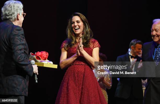 Catherine, Duchess of Cambridge, accepts a gift of tap shoes from producers Michael Linnet and Michael Grade during the Opening Night Royal Gala...