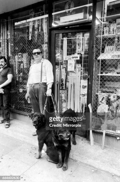 Brixton shopkeeper prepares to defend his stock against looters with dogs shortly after the riots, 12th July 1981.